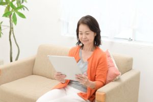 レンタルしたiPadでネットを閲覧する女性